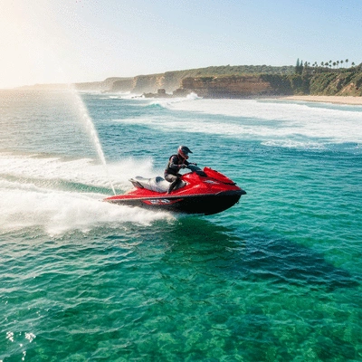 Jet ski speeding across clear blue water in Australia with a scenic coastline in the background